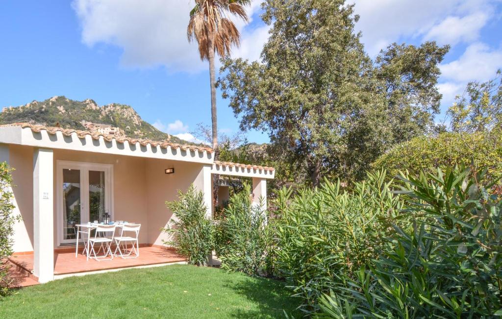a house with a table and chairs in a yard at Bilocale in Costa Rei