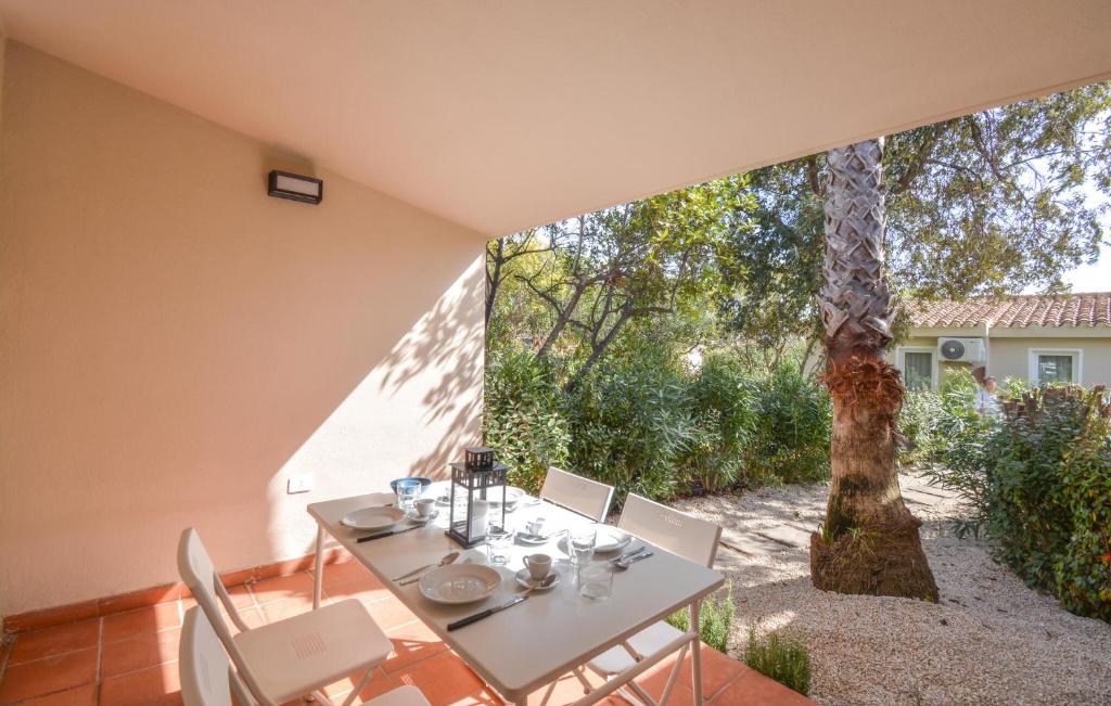 a table and chairs on a patio with a tree at Bilocale in Costa Rei