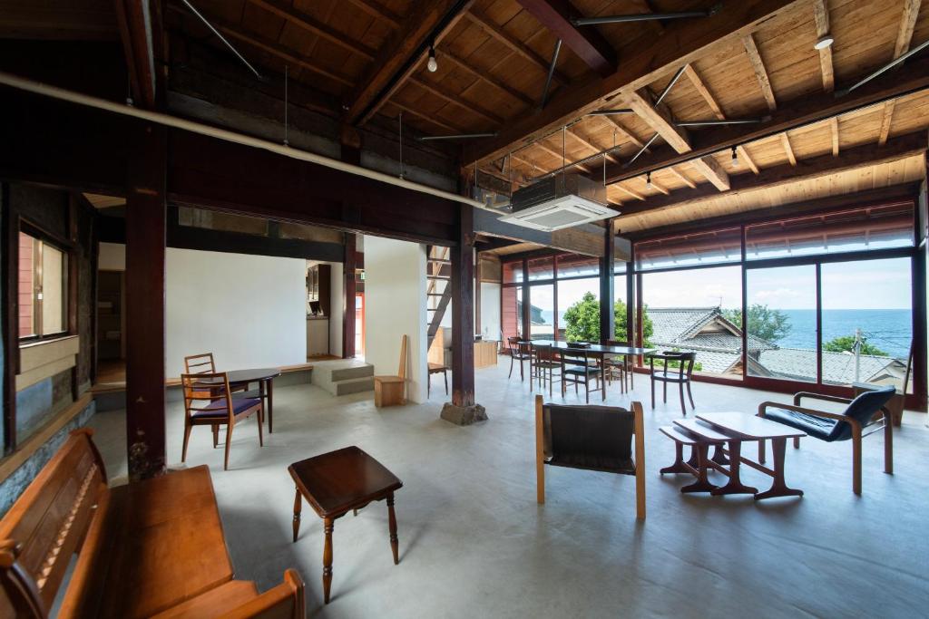 a large room with tables and chairs and windows at 点景 tenkei in Fukui