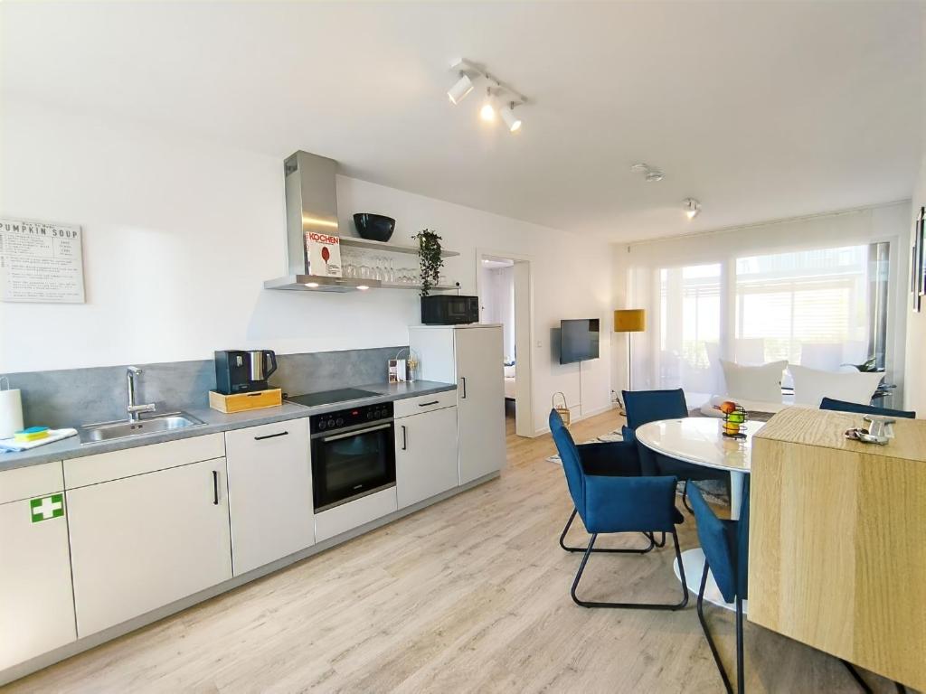 a kitchen with white cabinets and a table and chairs at CityVibe Apartment für bis zu 4 in Erlangen