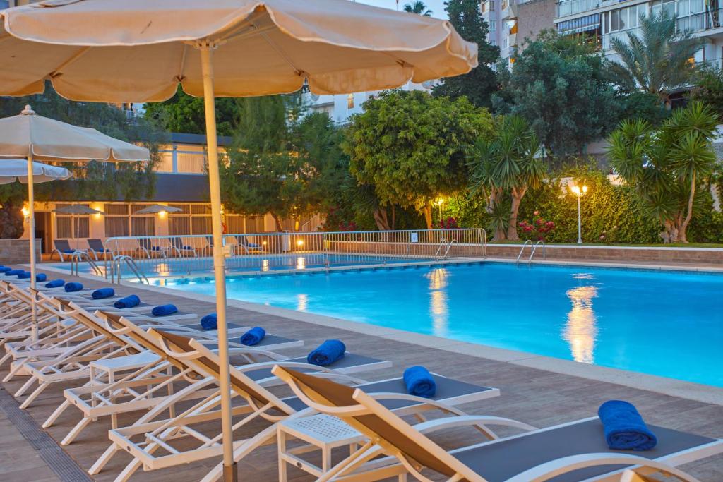 a swimming pool with lounge chairs and an umbrella at Hotel Joan Miró Museum in Palma de Mallorca