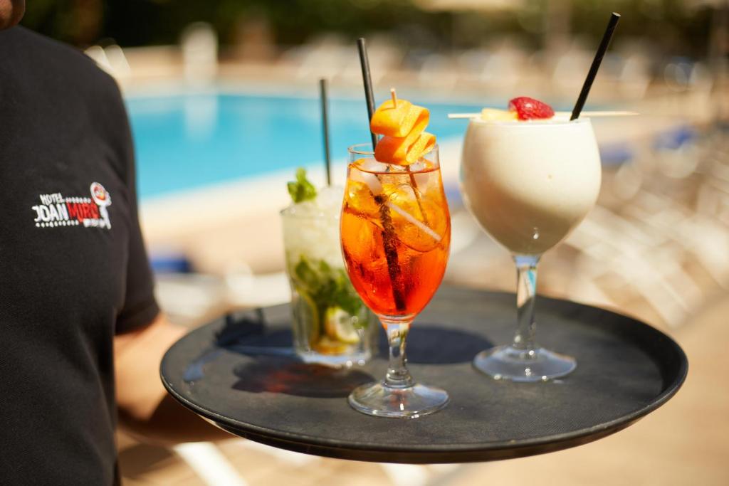 two drinks on a tray next to a pool at Hotel Joan Miró Museum in Palma de Mallorca
