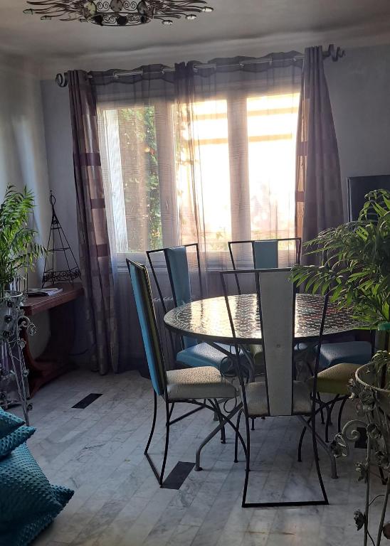 une salle à manger avec une table et des chaises et une fenêtre dans l'établissement La baraquette turquoise, à Sète