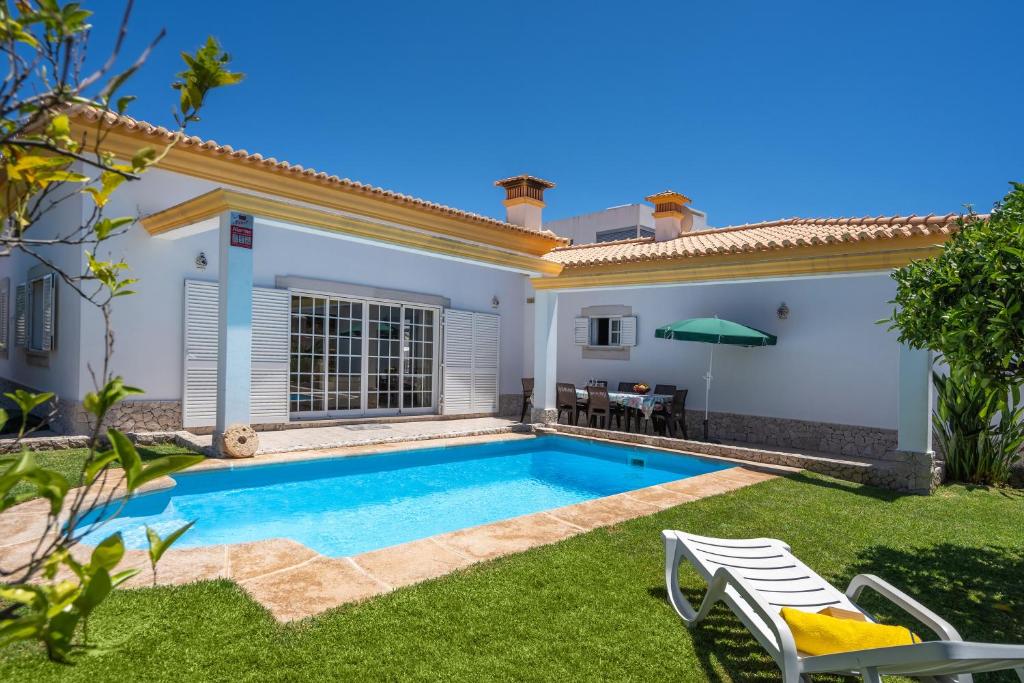 a villa with a swimming pool in a yard at Casa Village in Senhora do Verde
