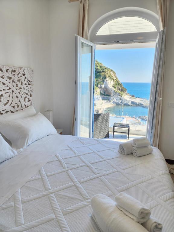 une chambre avec un lit avec vue sur l'océan dans l'établissement Divina Seaside Suite Ischia, à Ischia