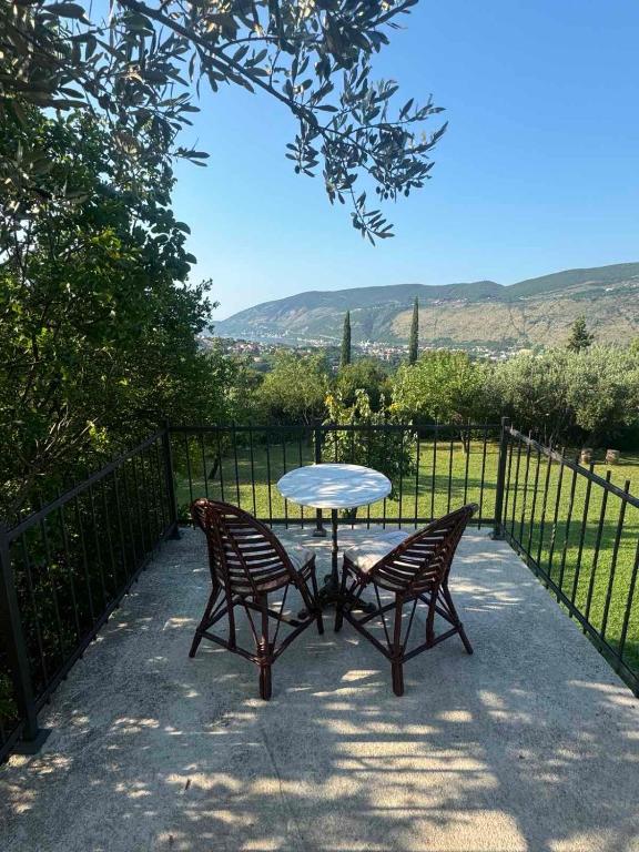 un tavolo e due sedie accanto a una recinzione di Apartman Sofija HN a Herceg-Novi