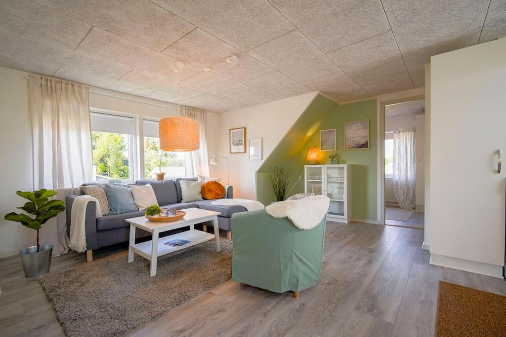 een woonkamer met een bank en een tafel bij FeWo Sjælland B in Sindal