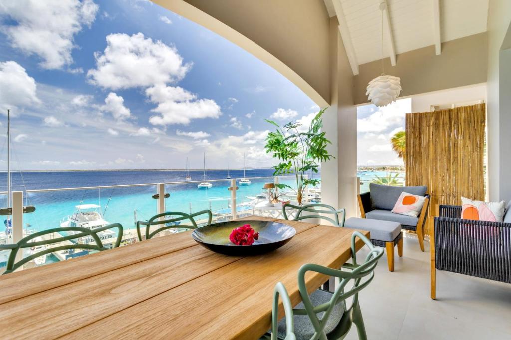 a dining room with a table and a view of the ocean at Las Dunas with Stunning Sea View and Shared Pool in Kralendijk