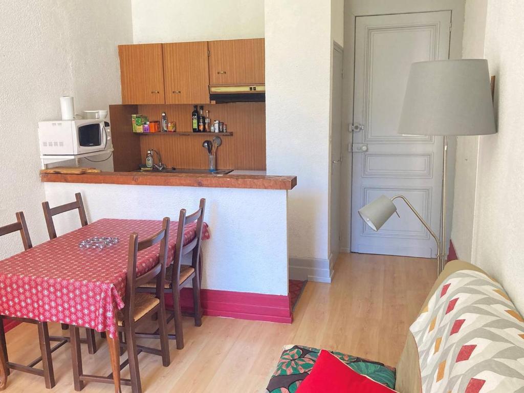 une cuisine avec une table et une cuisine avec une table et des chaises dans l'établissement Charmant T2, 4 pers, Centre Cauterets, Proche Télécabine, Parking Gratuit - FR-1-234-313, à Cauterets