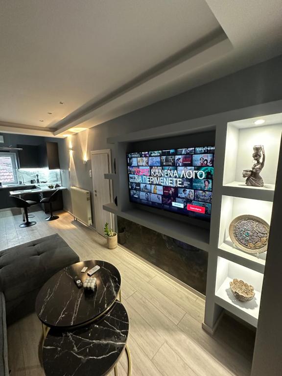 a living room with a large television and a table at Asteris luxury house in Polygryos