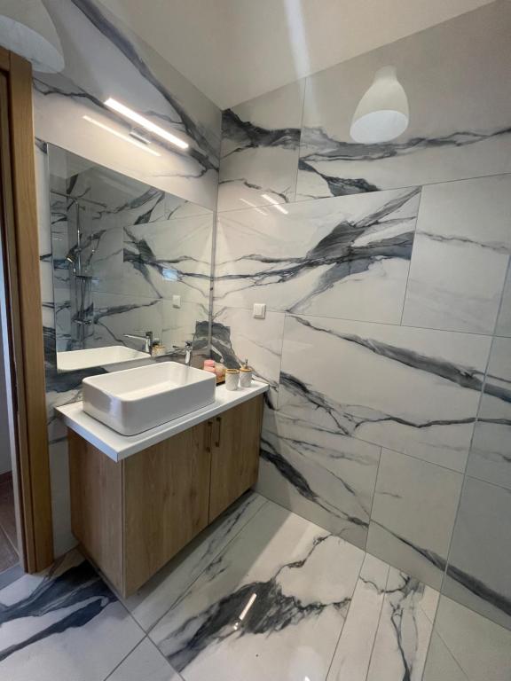 Ionian home في Exanthia: حمام مع حوض وجدار من الرخام