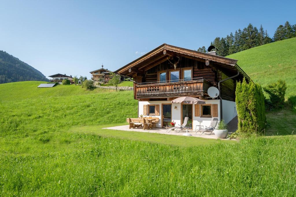 a house on top of a hill with green grass at Chalet der Erzstadl in Kirchberg in Tirol