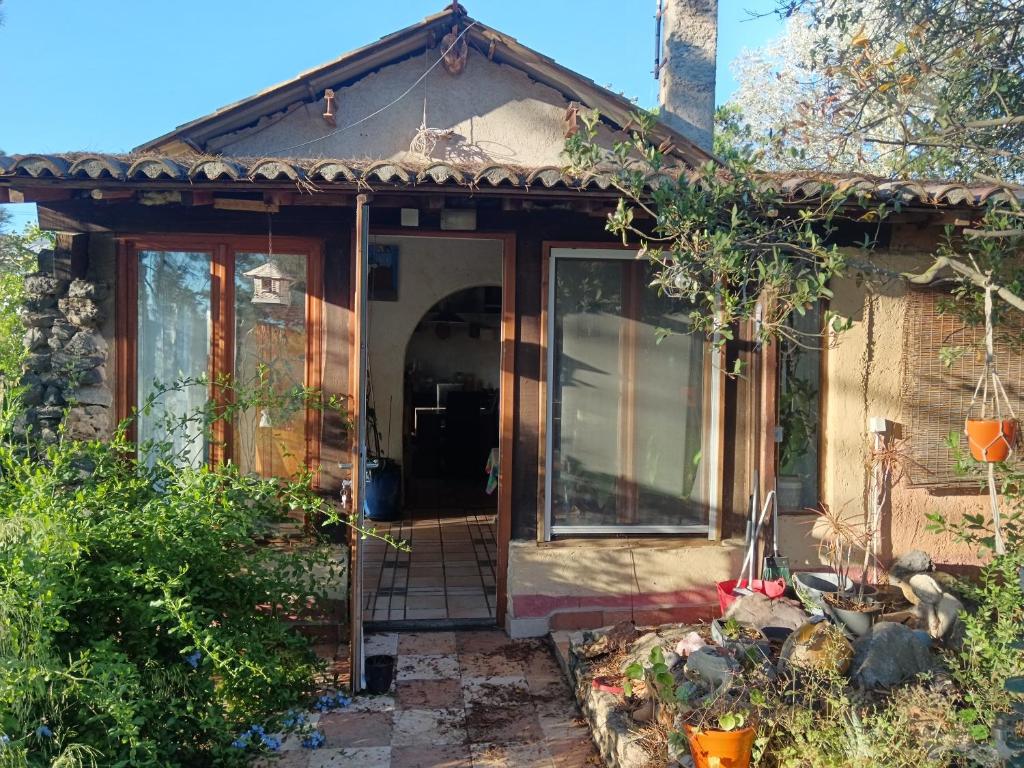 une petite maison avec une porte coulissante en verre dans l'établissement Bohémienne, à La Celle-sous-Gouzon