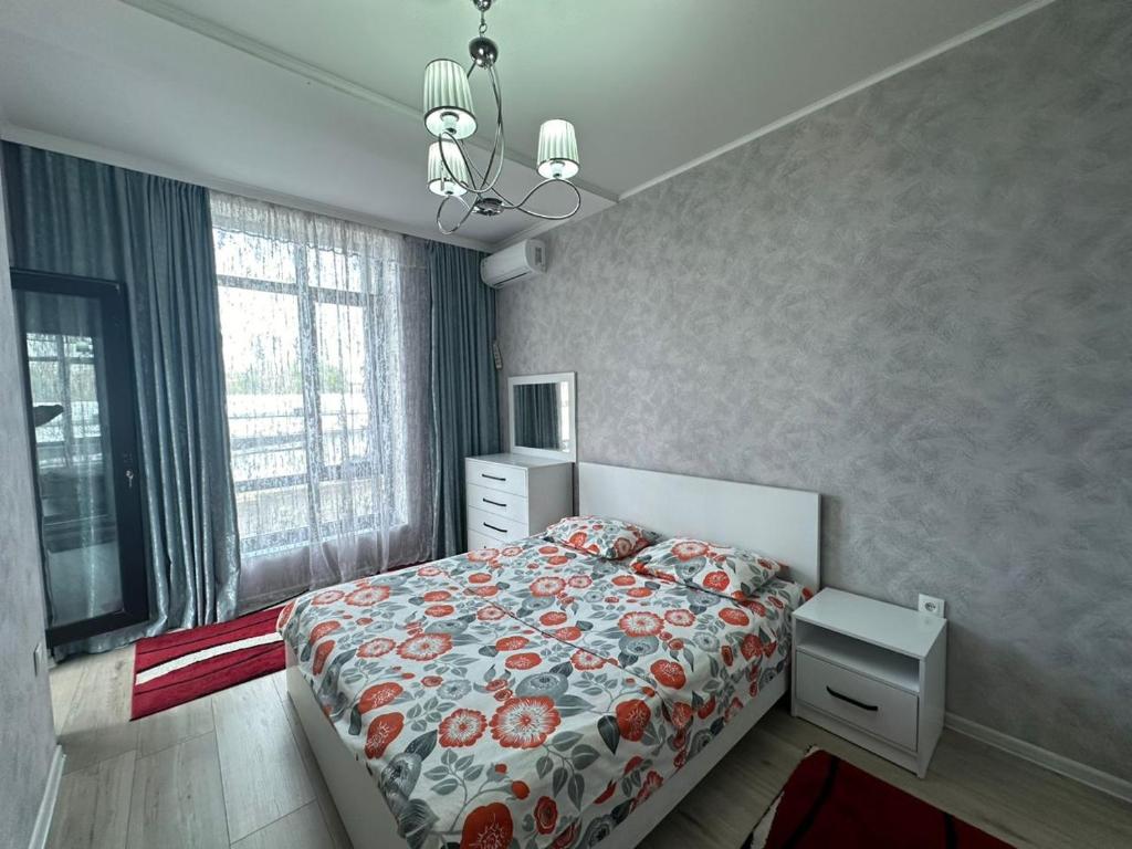 a bedroom with a bed with a floral bedspread at Diamond city in Bishkek