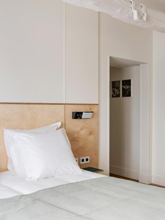 a bedroom with a white bed with a white pillow at New Hotel Opéra in Paris