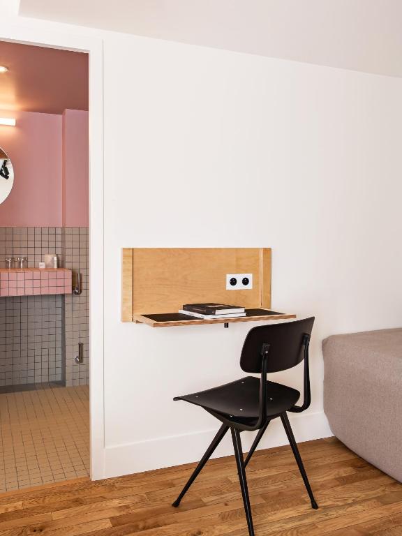 a black chair in a room with a kitchen at New Hotel Opéra in Paris