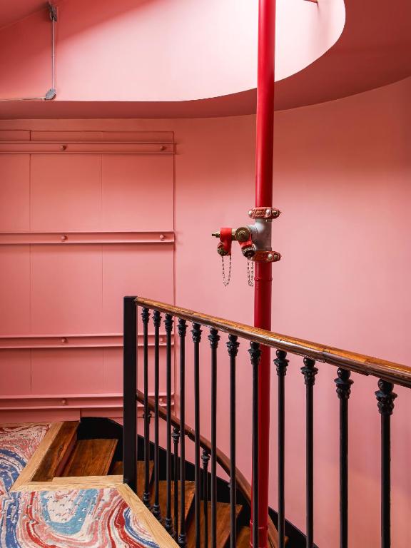 a staircase with a red wall and a red pole at New Hotel Opéra in Paris