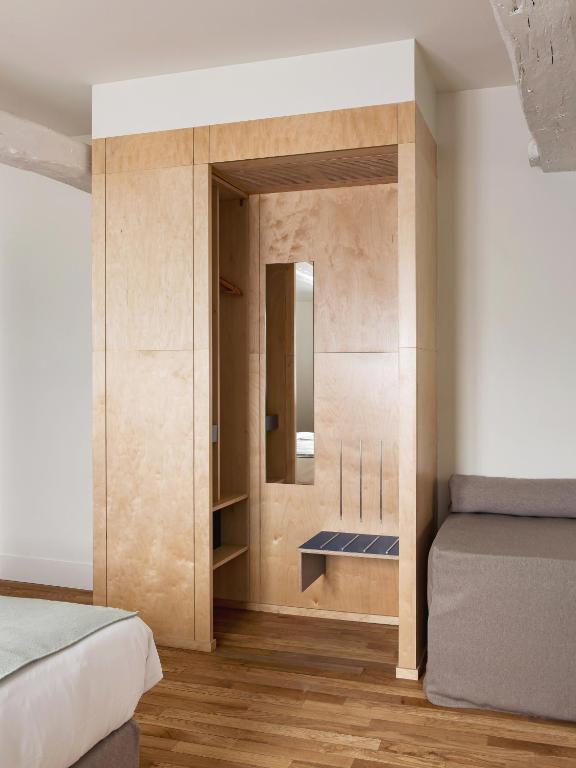 a bedroom with a bed and a mirror on the wall at New Hotel Opéra in Paris