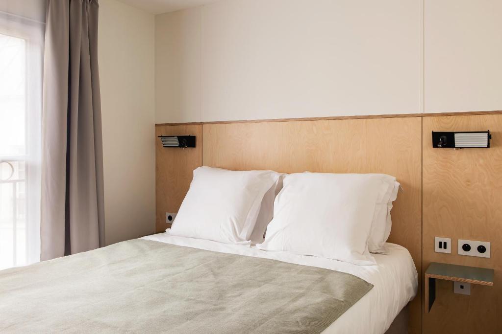a bedroom with a bed with white sheets and pillows at New Hotel Opéra in Paris