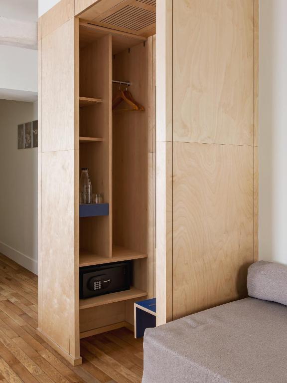 a room with a closet with a bed in it at New Hotel Opéra in Paris
