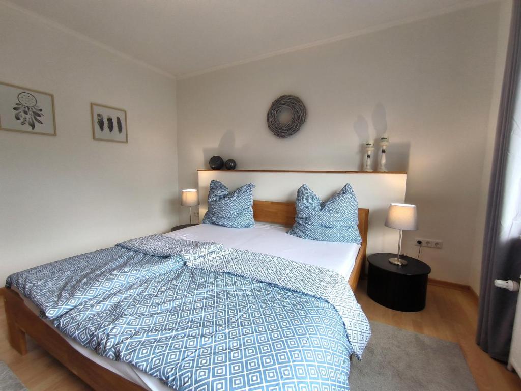 a bedroom with a large bed with blue pillows at Ferienwohnung Kiara - mit Terrasse, 2 Schlafzimmern und einem großem Wohnzimmer in Handewitt