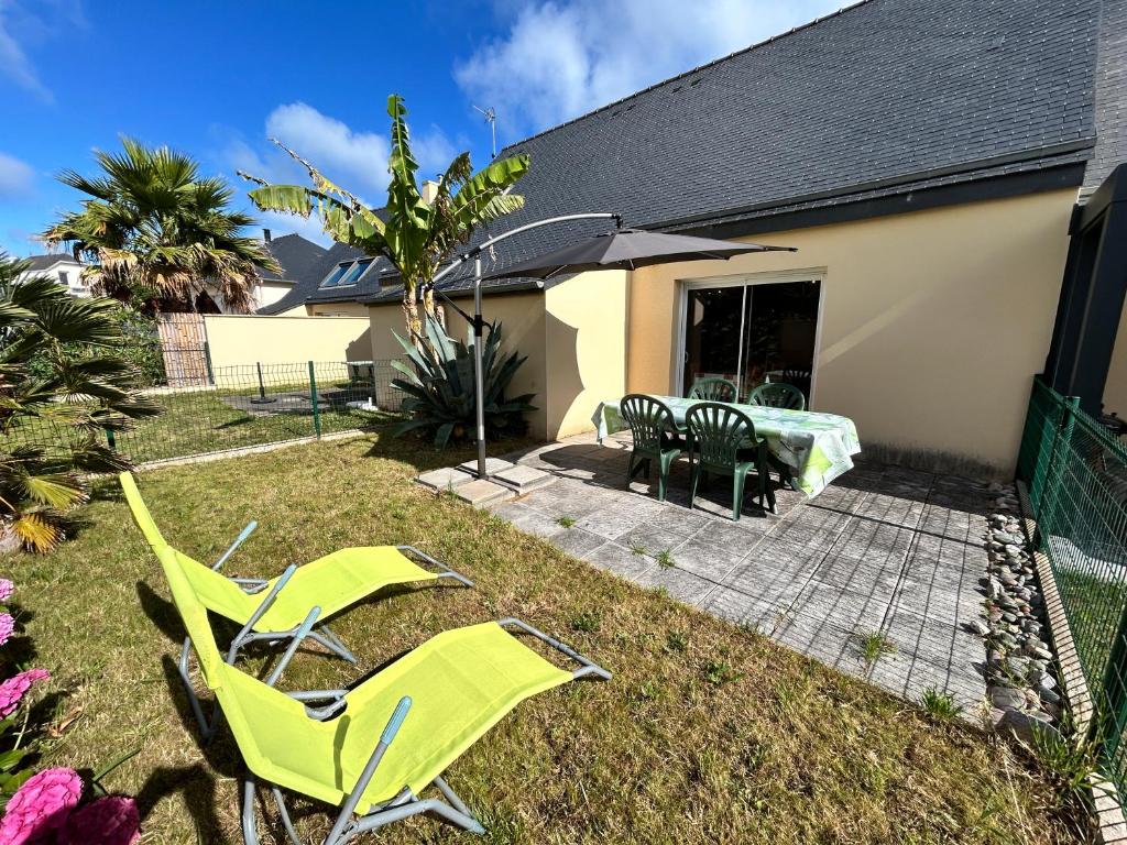a yard with green lawn chairs and a table at 1002 - Maison 5p à 1km de la Plage des Vallées in Pléneuf-Val-André