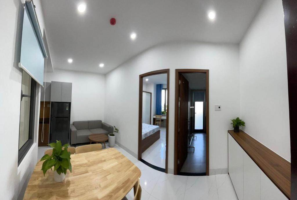 a dining room with a table and a living room at CH Home in Danang