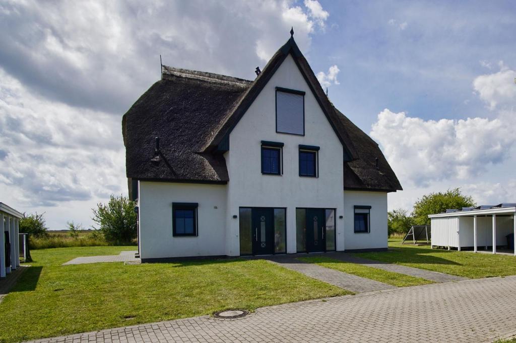a white house with a thatched roof at Villa Vogelblick Haushälfte 01 in Vaschvitz