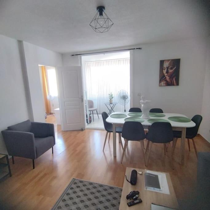 un salon avec une table et des chaises de salle à manger dans l'établissement Au calme et proche de tout !, à Perpignan