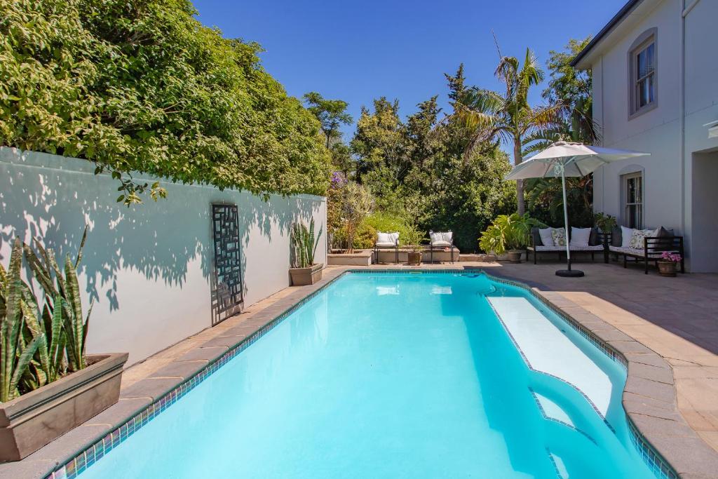 a swimming pool in a yard with a wall at Luxury Five Bed Villa in the Heart of Franschhoek in Franschhoek
