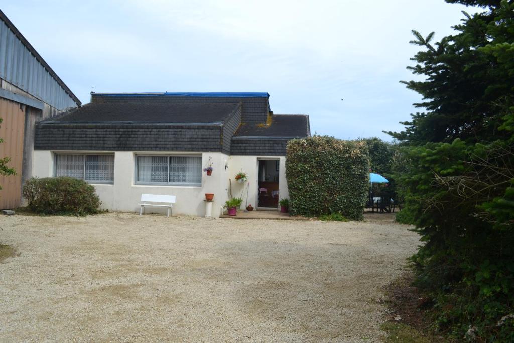 une maison blanche avec un banc devant dans l'établissement Les Fromentines, à Saint-Pol-de-Léon