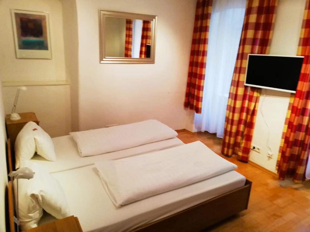 Una habitación con una cama con tres almohadas. en Living inStein, en Krems an der Donau