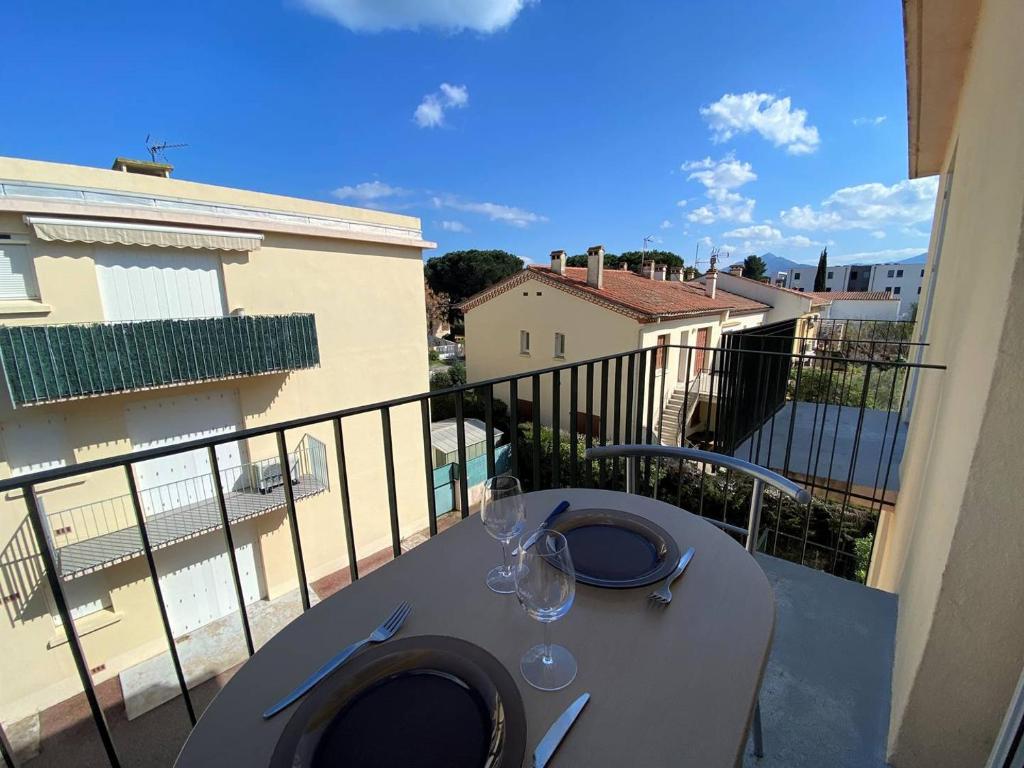 - une table avec des verres à vin sur le balcon dans l'établissement Appartement 2 pièces - 4 couchages - Argeles Sur Mer AR860-B27, à Argelès-sur-Mer