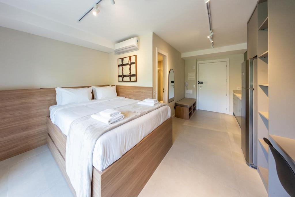 Un dormitorio con una cama grande con sábanas blancas. en BHomy Caraibas, en São Paulo