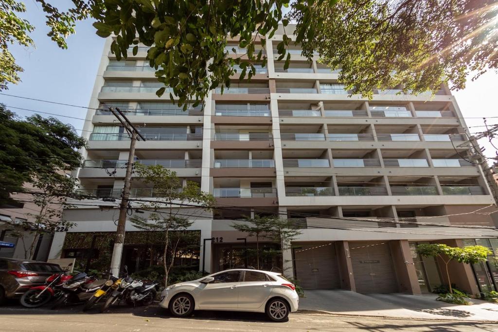 un coche aparcado delante de un edificio alto en BHomy Caraibas, en São Paulo