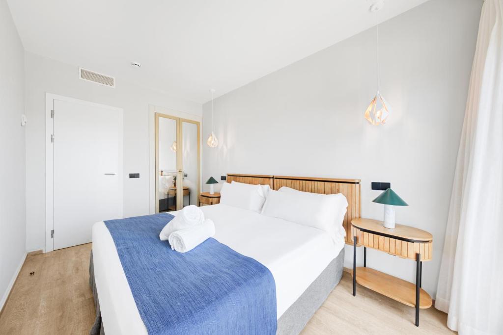 a bedroom with a large white bed and a table at Hotel Ankaa - Adults Only in Porto Cristo