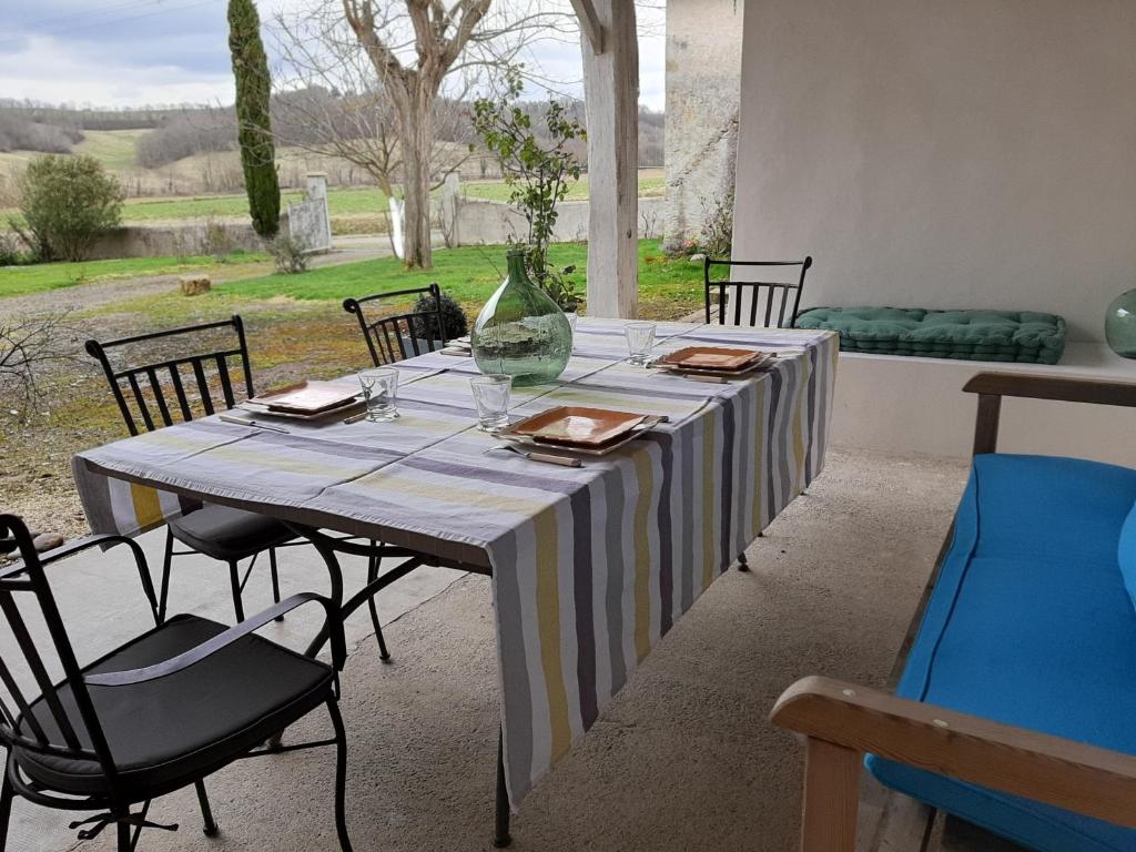 une table avec des chaises et un vase au-dessus dans l'établissement Maison Paradis Pr Enfants, à Troncens