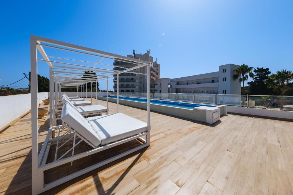 a rooftop deck with lounge chairs and a pool at Hotel Ankaa - Adults Only in Porto Cristo