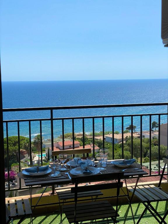 - une table sur un balcon avec vue sur l'océan dans l'établissement VUE MER EXCEPTIONNELLE !! Studio calme et lumineux sur la prestigieuse route des Sanguinaires à Ajaccio, à Ajaccio