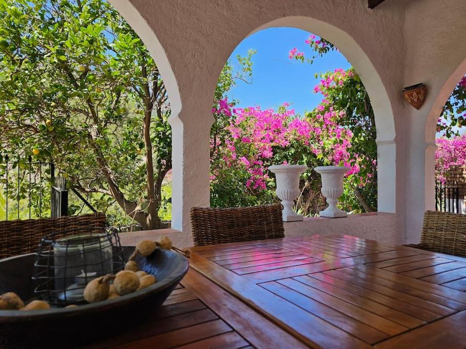 a dining room with a table and two arched windows at Villa Finca el Carril in Vélez de Benaudalla