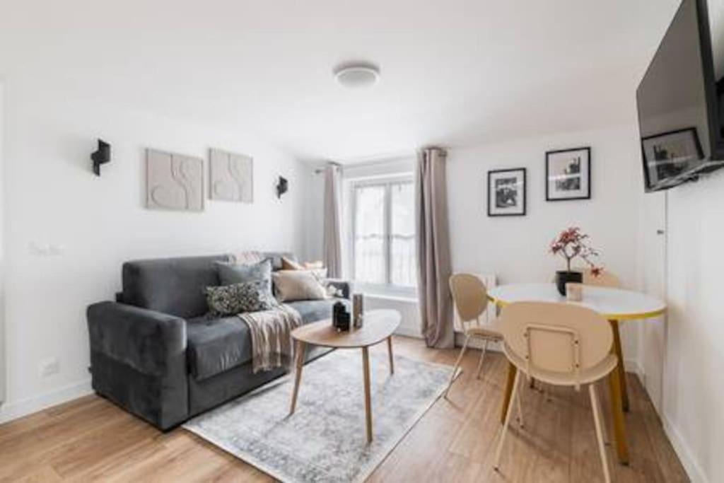 un salon avec un canapé et une table dans l'établissement Cosy flat Grand boulevard 4 pers, à Paris