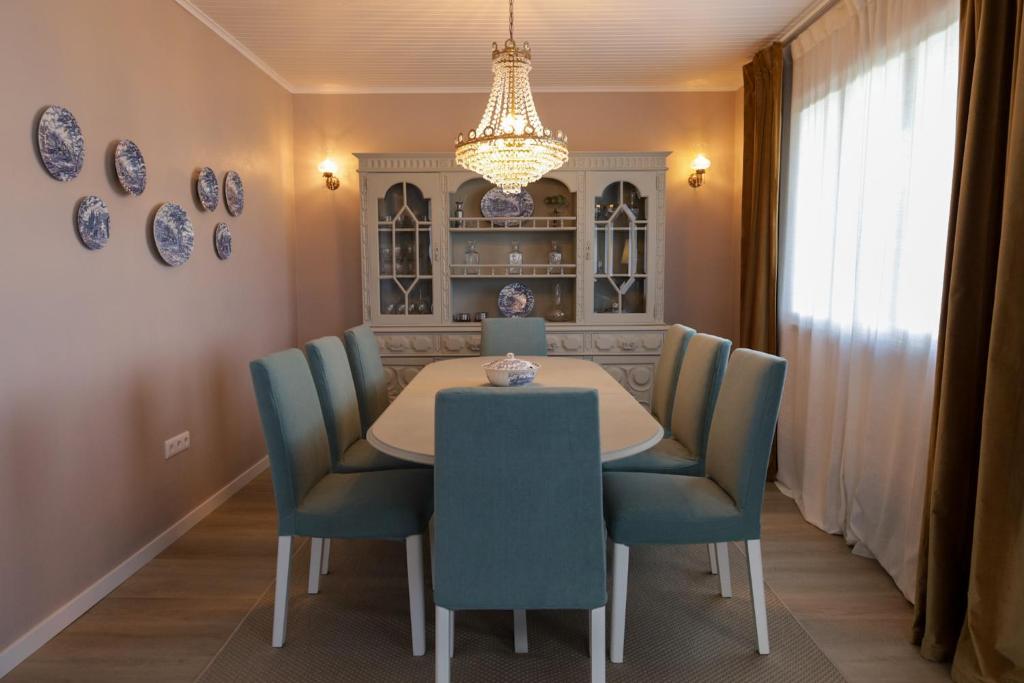 a dining room with a table and blue chairs at Alojamento Raízes da Montanha RRAL 4596 in Madalena