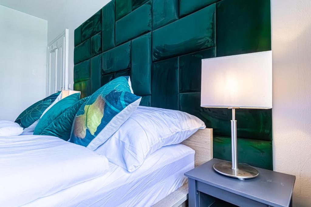 a bedroom with a bed with a green headboard at Convenient 3-BR Shared Apt, 15 Min to Landstraße Hub in Vienna