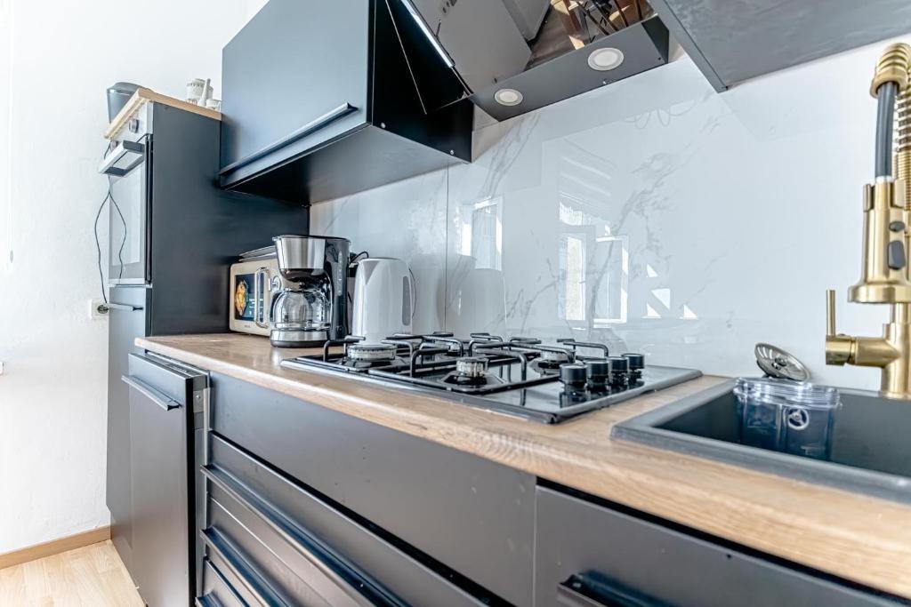 a kitchen with a stove top oven next to a sink at Convenient 3-BR Shared Apt, 15 Min to Landstraße Hub in Vienna