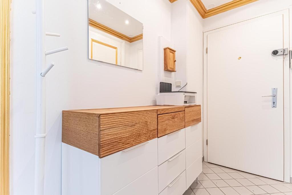 a kitchen with white cabinets and a wooden counter at Convenient 3-BR Shared Apt, 15 Min to Landstraße Hub in Vienna