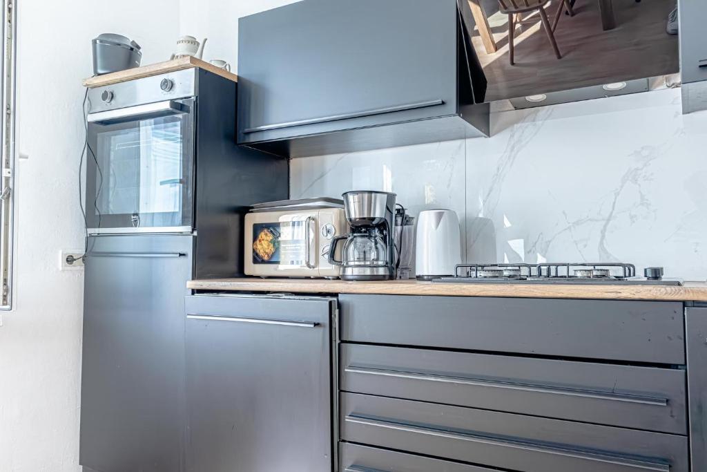 a kitchen with a counter with a microwave and a refrigerator at Convenient 3-BR Shared Apt, 15 Min to Landstraße Hub in Vienna