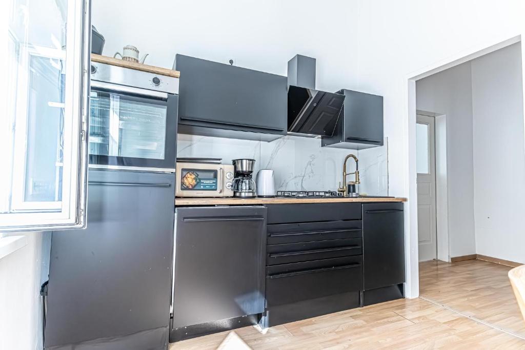 a kitchen with stainless steel appliances in a room at Convenient 3-BR Shared Apt, 15 Min to Landstraße Hub in Vienna