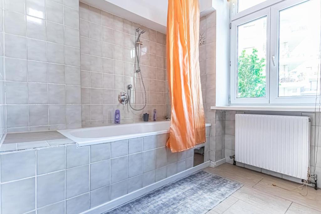 a bathroom with a bath tub and a window at Convenient 3-BR Shared Apt, 15 Min to Landstraße Hub in Vienna