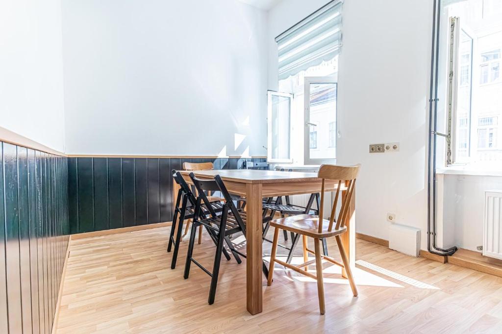 a dining room with a wooden table and chairs at Convenient 3-BR Shared Apt, 15 Min to Landstraße Hub in Vienna