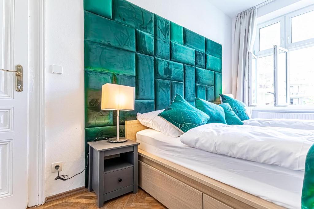a bedroom with two beds and a green accent wall at Convenient 3-BR Shared Apt, 15 Min to Landstraße Hub in Vienna